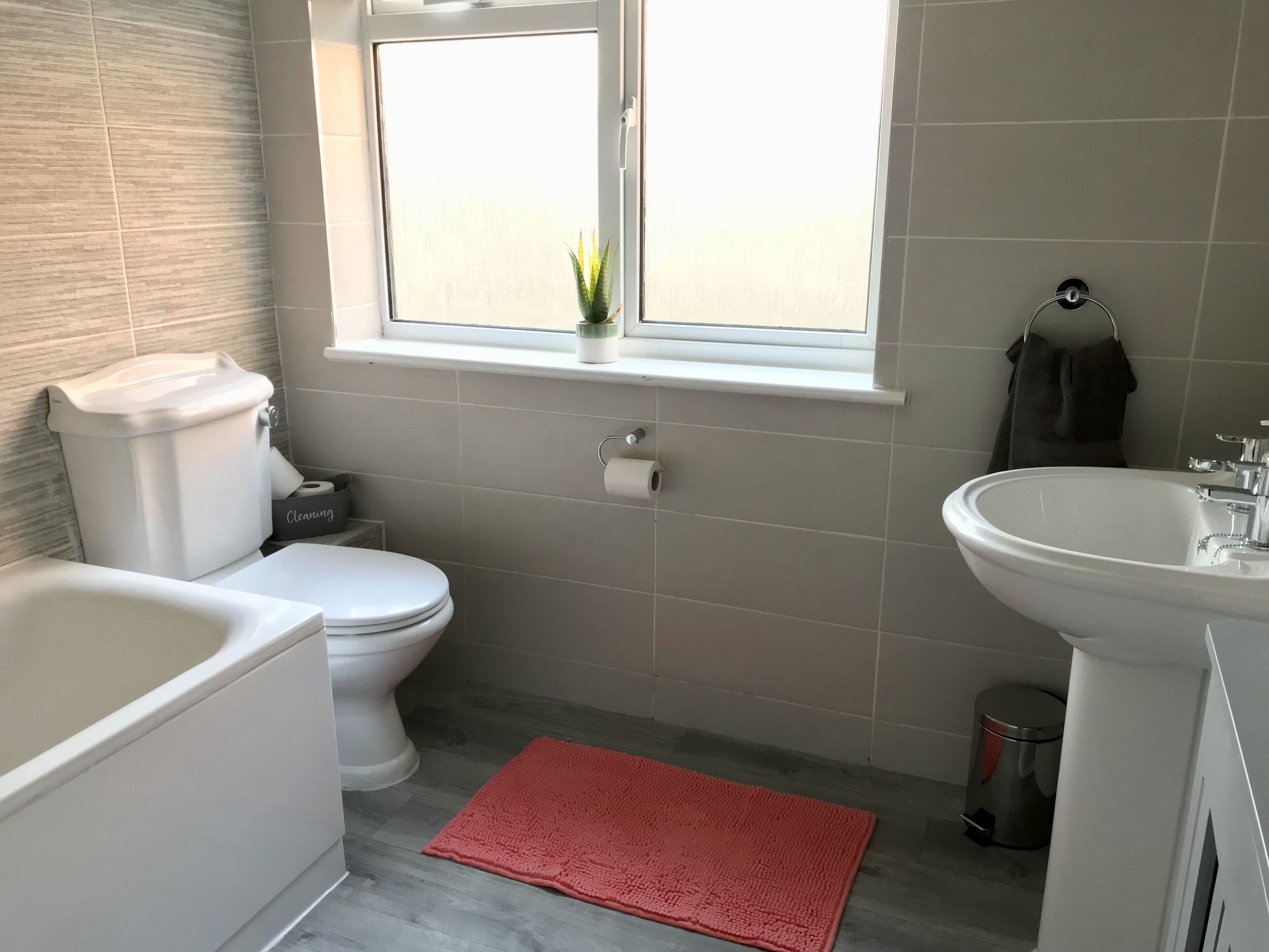 A bathroom with a toilet, sink, and bathtub.