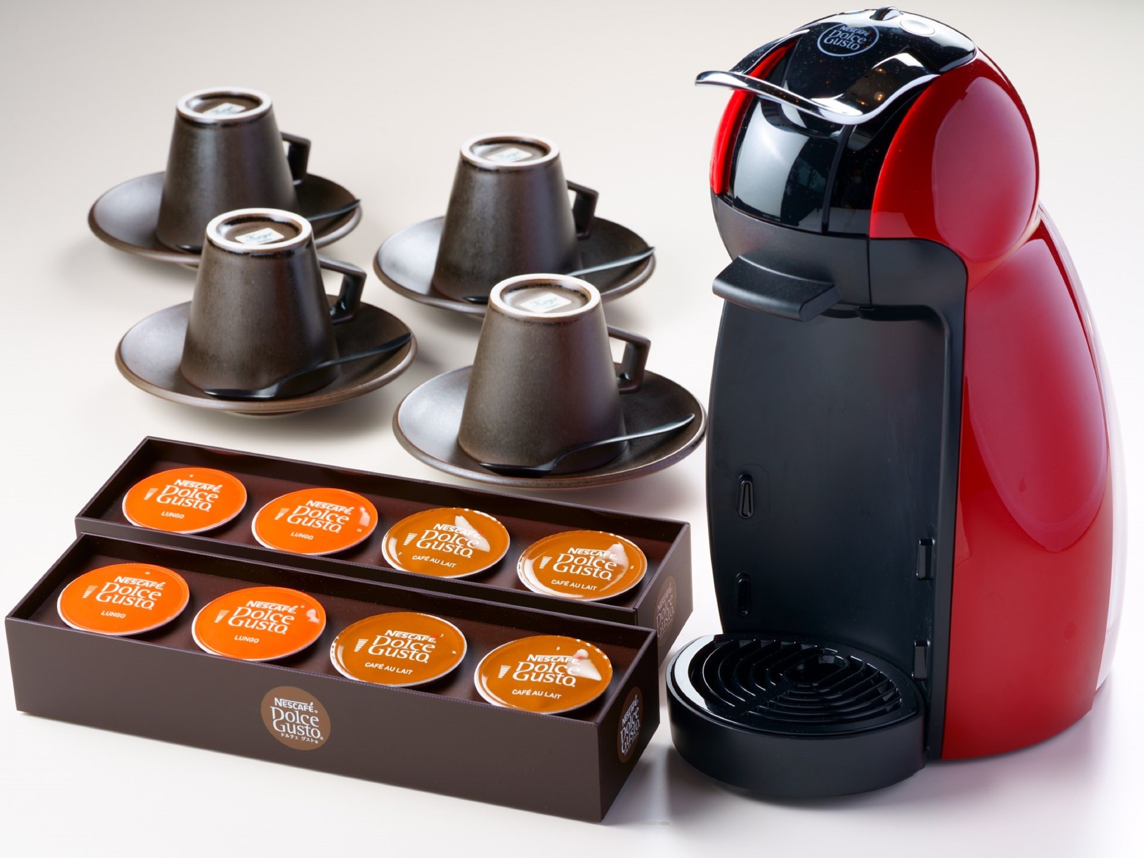 A coffee machine with multiple coffee cups and a box of coffee pods.