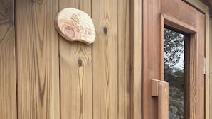 Une porte en bois avec une poignée en métal et un trou de serrure, ainsi qu’une plaque en bois portant une inscription.