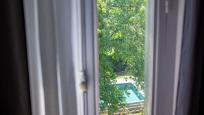 A window with a view of a lush green landscape and a playground.