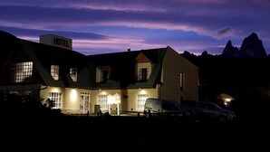 Un hôtel doté d’une entrée imposante, de nombreuses fenêtres et d’une façade bien éclairée.