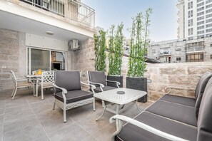 Eine Außenpatio mit Sitzgelegenheit, inklusive Tisch und Stühlen, sowie Blumentöpfen.
