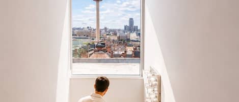 A staircase with a view of a tower and cityscape through a window.