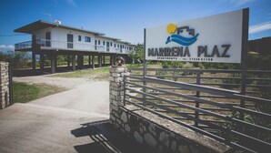 A sign for Marrenia Plaza Apartments with a modern building in the background. - MariRena plaz (North Kynouria)