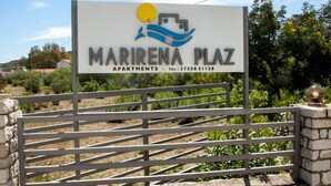 A sign for Mariena Plaza Apartments with a logo, name, and contact number. - MariRena plaz (North Kynouria)