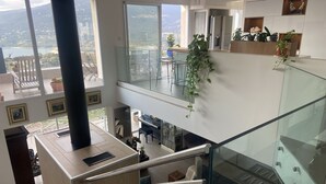 A modern interior with a glass staircase, a piano, and a balcony with a view of the landscape. - Villa Propriano 6 to 8 people VILLA WITH POOL AND SEA VIEW (VIGGIANELLO)