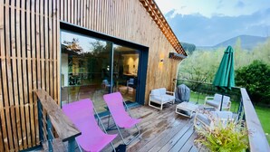A wooden deck with outdoor seating and a glass door leading to an interior space. - NO, AVAILABLE AD BEING REMOVED (Ceilhes-et-Rocozels)