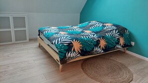 A bedroom with a bed, a woven rug, and a skylight. - Country house with jacuzzi (Cheilly-lès-Maranges)