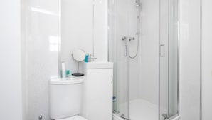 A modern bathroom with a glass-enclosed shower, a toilet, and a sink. - Cosy and Functional 1 Bedroom Flat in London (London)