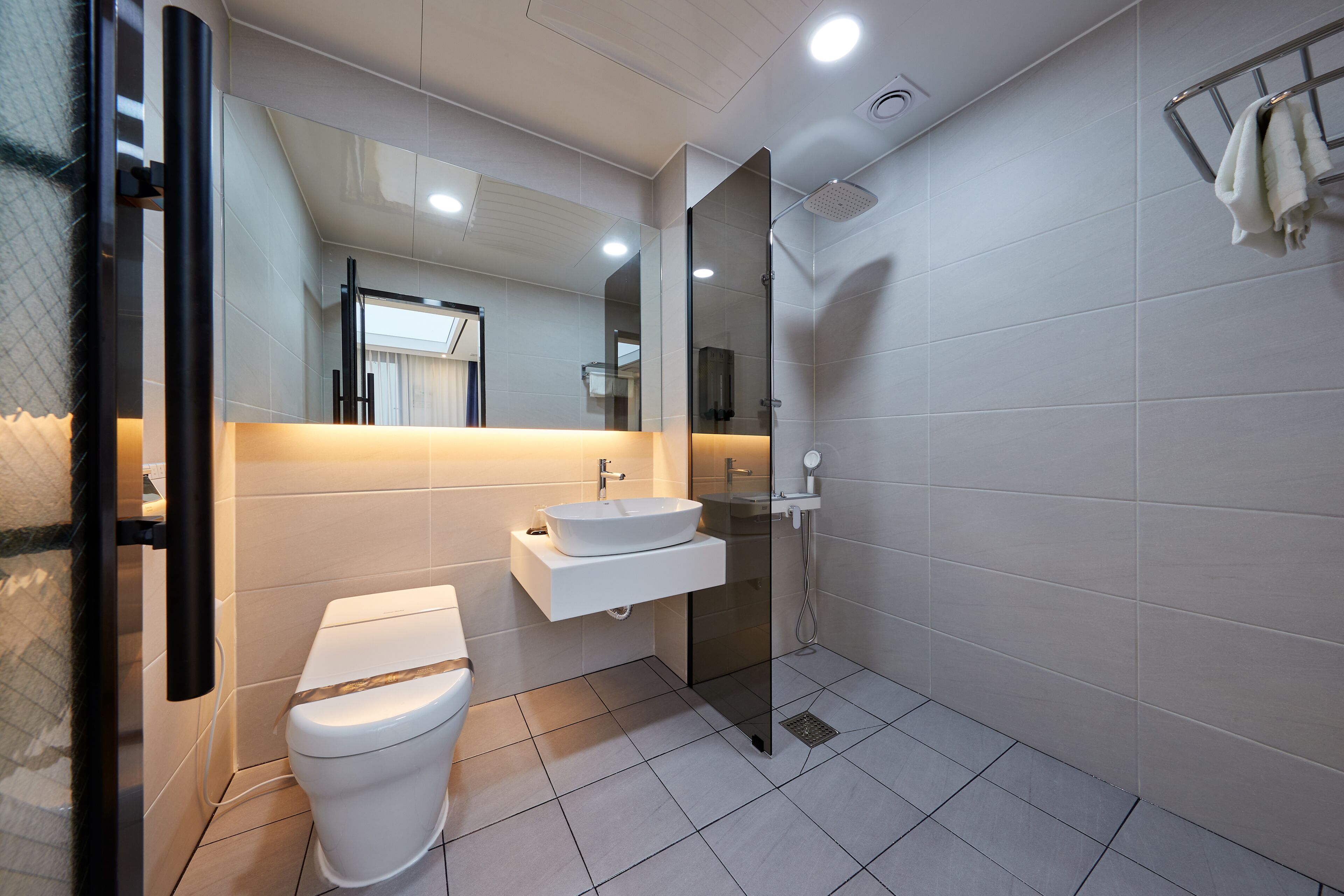 Un baño moderno con inodoro, lavabo y ducha.