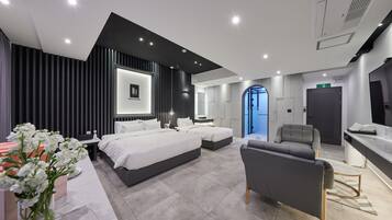 Une chambre d’hôtel moderne équipée d’un grand lit, d’un canapé, d’un bureau et d’une salle de bain.