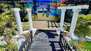 A wooden pathway leading to a building with a colorful mural on the entrance.