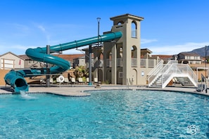 A swimming pool with a water slide, a lifebuoy, and a staircase leading to a tower-like structure. - Lazy River Retreat by RedAwning (Washington)