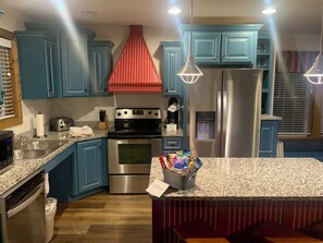 Enjoy cooking in this well-equipped kitchen with a refrigerator, oven, and granite countertop.