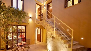 A staircase leading to an upper level, a seating area with chairs and a table, and a potted plant. - Villa in Rethymno Old Town w/Private Pool & BBQ (Rethymno)