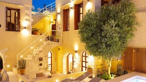 A modern building with a swimming pool, outdoor seating, and a staircase leading to an upper level. - Villa in Rethymno Old Town w/Private Pool & BBQ (Rethymno)