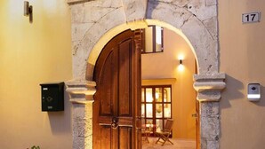 An arched entrance with a wooden door, a potted plant, and a number sign. - Villa in Rethymno Old Town w/Private Pool & BBQ (Rethymno)