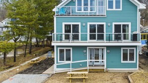Une maison à deux étages avec un balcon, un porche à l’avant et un garage apparent.