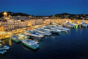 A marina with boats docked, a waterfront promenade, and buildings with balconies. - RARE! Saint-Tropez Port – Quai d'Honneur, Terrace, Sea View, 100m², A/C (Saint-Tropez)