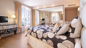 Habitación de hotel con una cama grande, televisión, escritorio y vistas de la ciudad.
