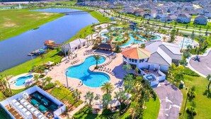 A resort with multiple swimming pools, a large water body, and residential buildings. - Themed Rooms & Lake Views: Your Kissimmee Escape! (Kissimmee)