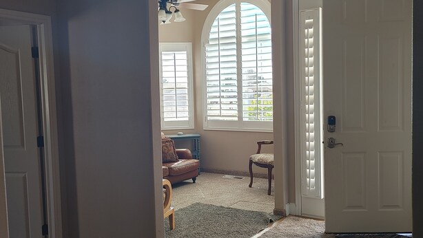 A spacious living room with a high ceiling, a large arched window, and a wooden floor. - #2 - Beautiful room with a view with a King bed (St. George)