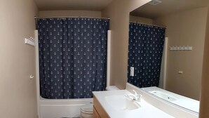 A bathroom with a bathtub, a toilet, a sink, and a mirror. - #2 - Beautiful room with a view with a King bed (St. George)