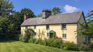 A two-story house with a green door, multiple windows, and a chimney. - Denbigh Hall (Leominster)
