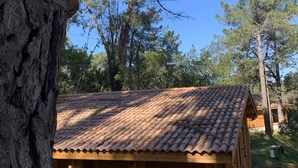 A wooden cabin with a tiled roof, surrounded by trees and a clear sky. - Porticcio house near the sea (Grosseto-Prugna)
