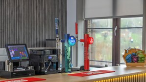 A bar area with a digital screen, a coffee machine, and a beer tap with a 'Cold River Cider' label. - Best Western Ebbw Vale (Ebbw Vale)
