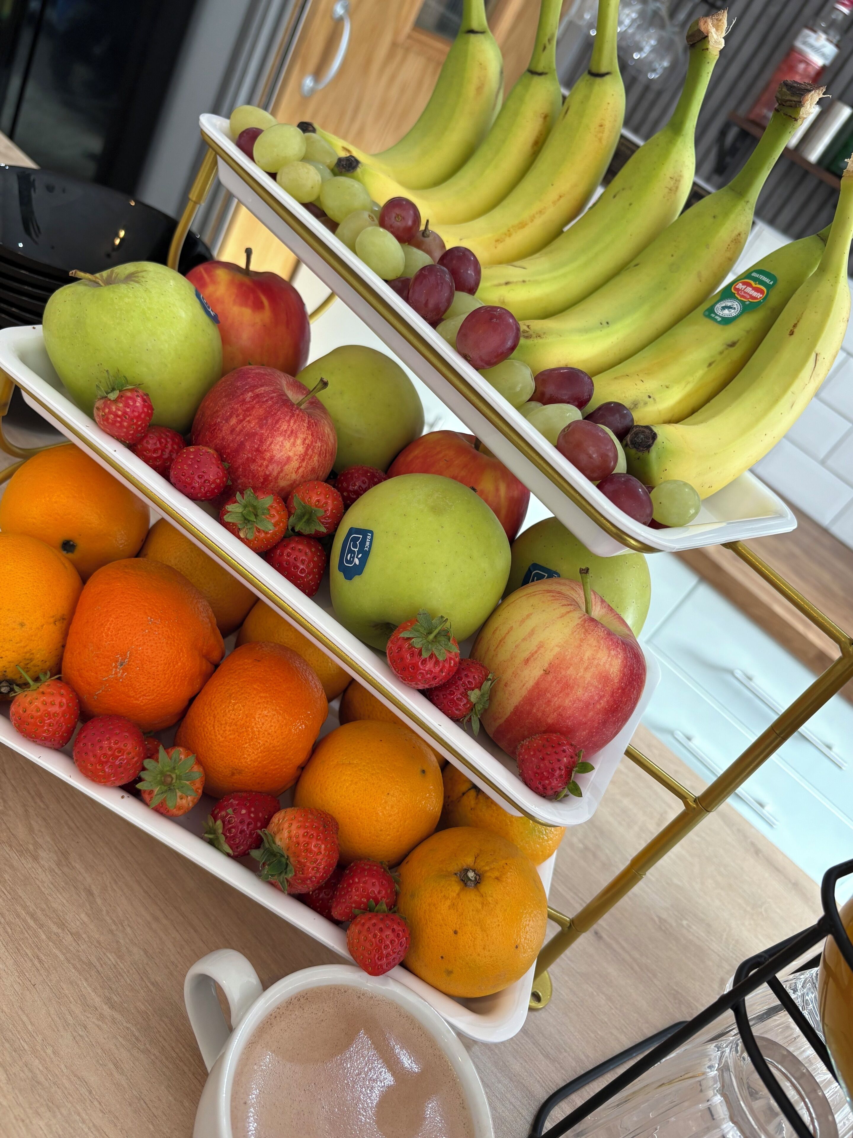 Une présentation de fruits comprenant des oranges, des pommes et des bananes.