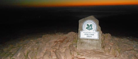 Monumento de piedra con una placa que indica 'The National Trust PEN Y FANN 886M'.