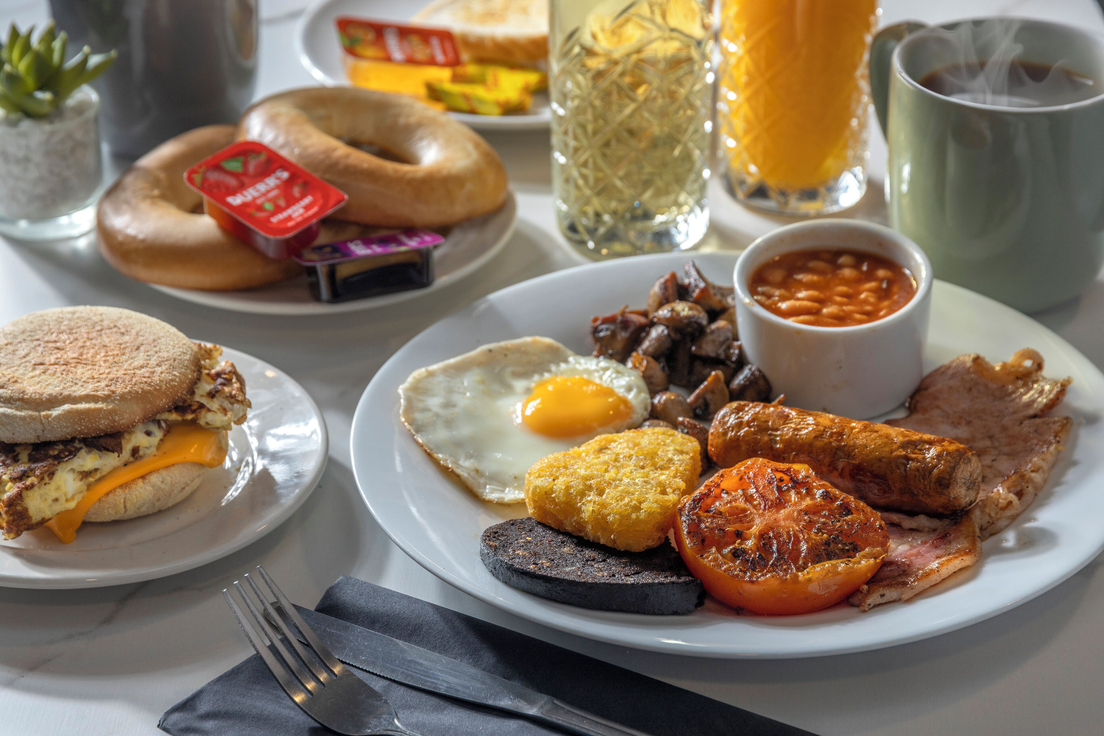 Une assiette de petit-déjeuner comprenant des œufs, du bacon, des saucisses et des haricots.