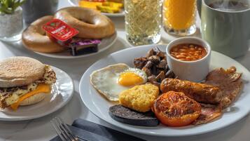 Une assiette de petit-déjeuner comprenant des œufs, du bacon, des saucisses et des haricots.