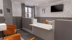 A modern hotel room with a large bed, a bedside table, and a window with curtains.