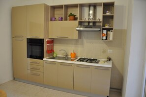 Een koelkast, een oven, een kookplaat, een koffiezetapparaat/waterkoker