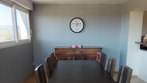 Ein Konferenzraum mit langem Tisch, Stühlen, einer Uhr und einem Fenster.