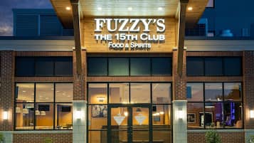 En bygning med et skilt, der står "FUZZY'S THE 15TH CLUB FOOD & SPIRITS".