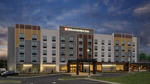 Un hôtel Hilton Garden Inn doté d’une façade moderne, de plusieurs étages et d’une entrée bien éclairée.