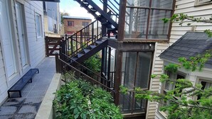 A multi-level outdoor space with a staircase, a small glass structure, and a garden area.