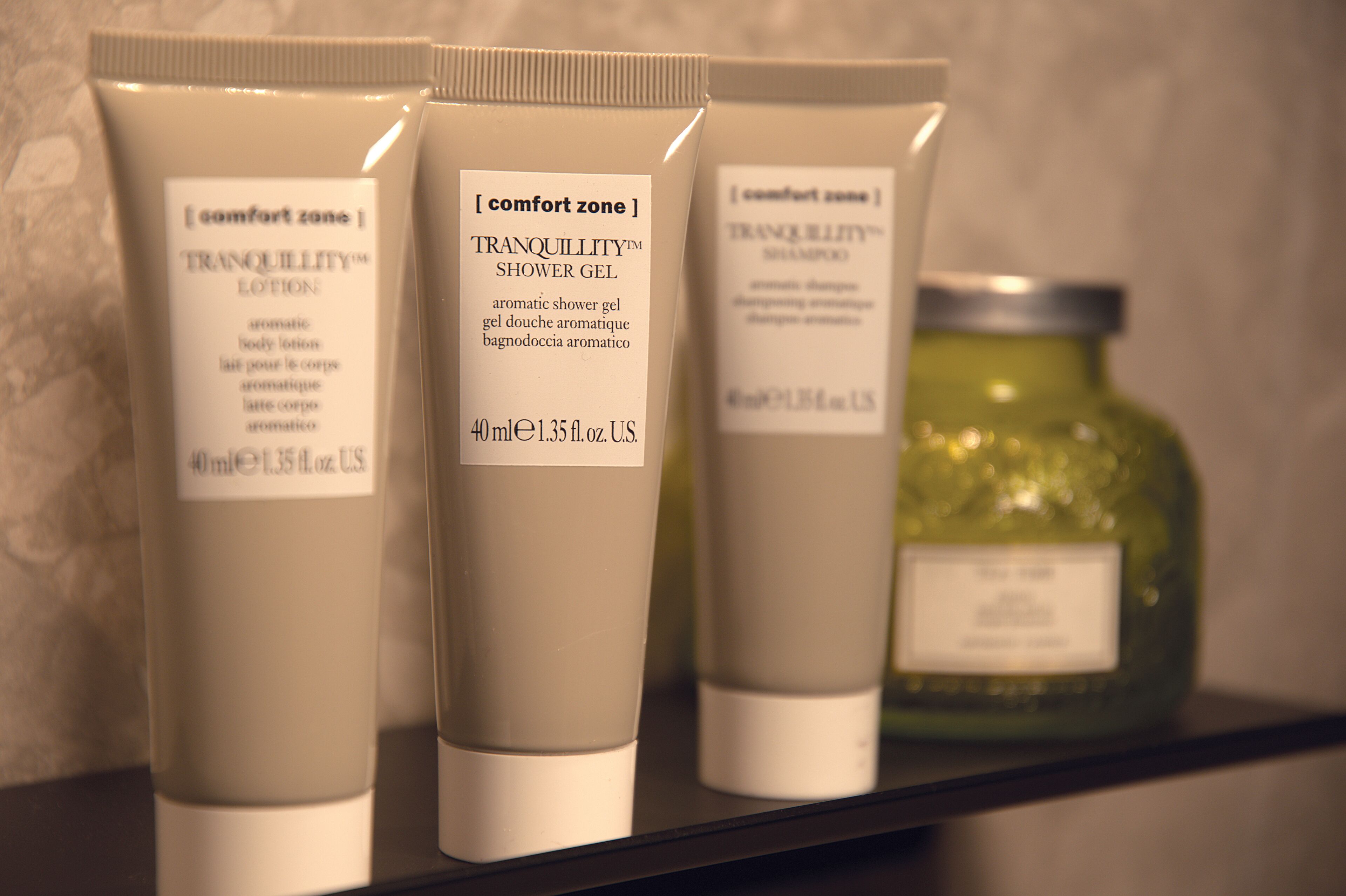 Three toiletry items on a shelf.