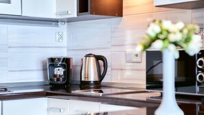 Eine moderne Küche mit Kaffeemaschine, Wasserkocher und einer Vase mit Blumen auf der Arbeitsfläche.