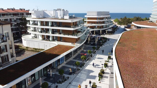 Ein modernes Mehrstöckiges Hotel mit Dachterrasse und Meerblick.