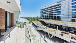 Ein modernes Hotel mit Dachterrasse, Sitzgelegenheiten im Freien und einem Sushi-Restaurant.