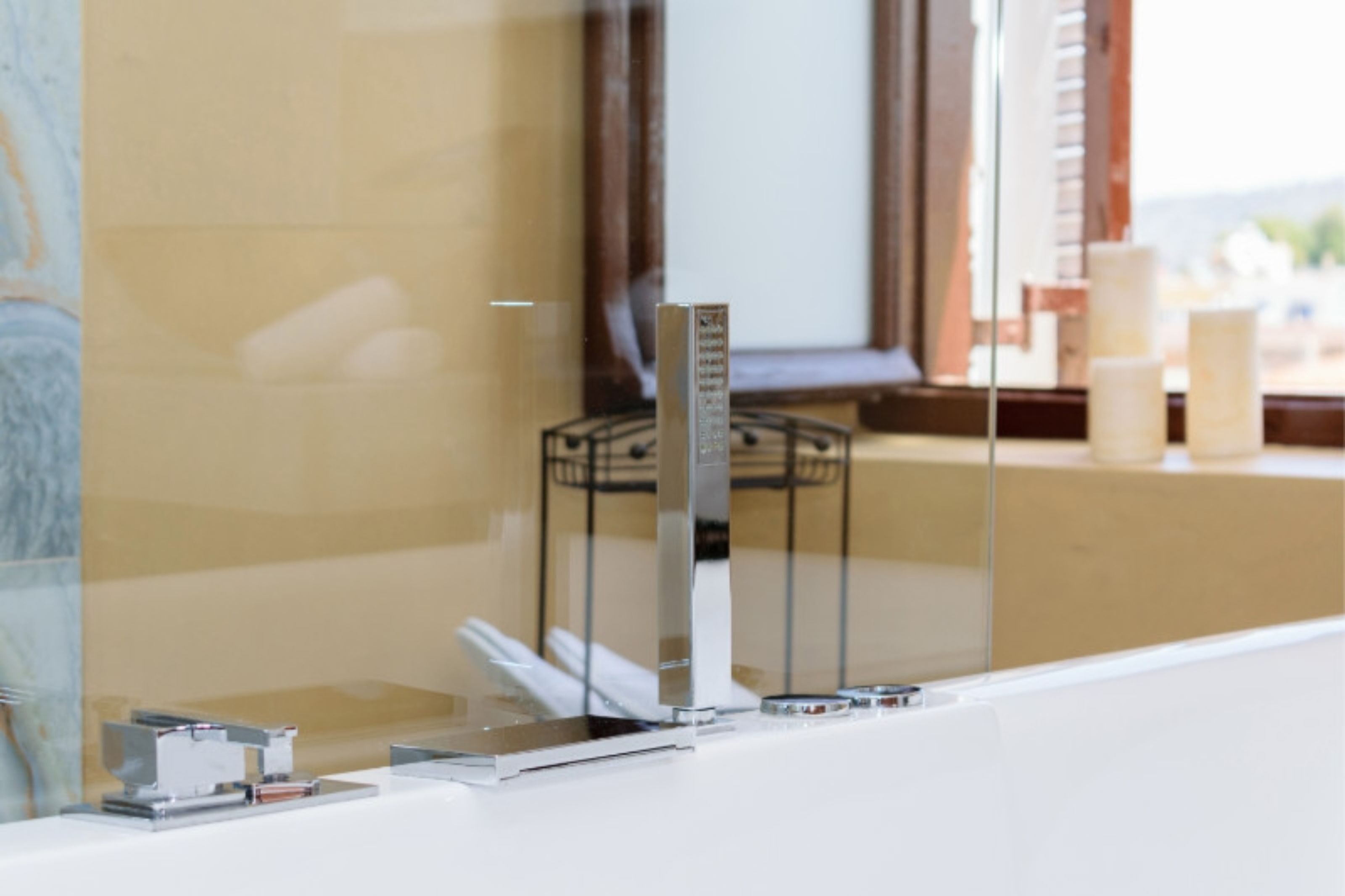 Un baño moderno con cabina de ducha de vidrio, encimera blanca y espejo.