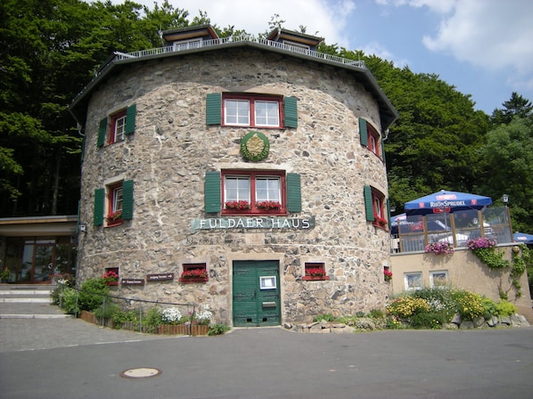 Un bâtiment en pierre avec une enseigne indiquant « FULDÄER HAUS » et des volets verts.