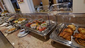 Een ontbijtbuffet met diverse gerechten, waaronder gebak, dips en snacks.