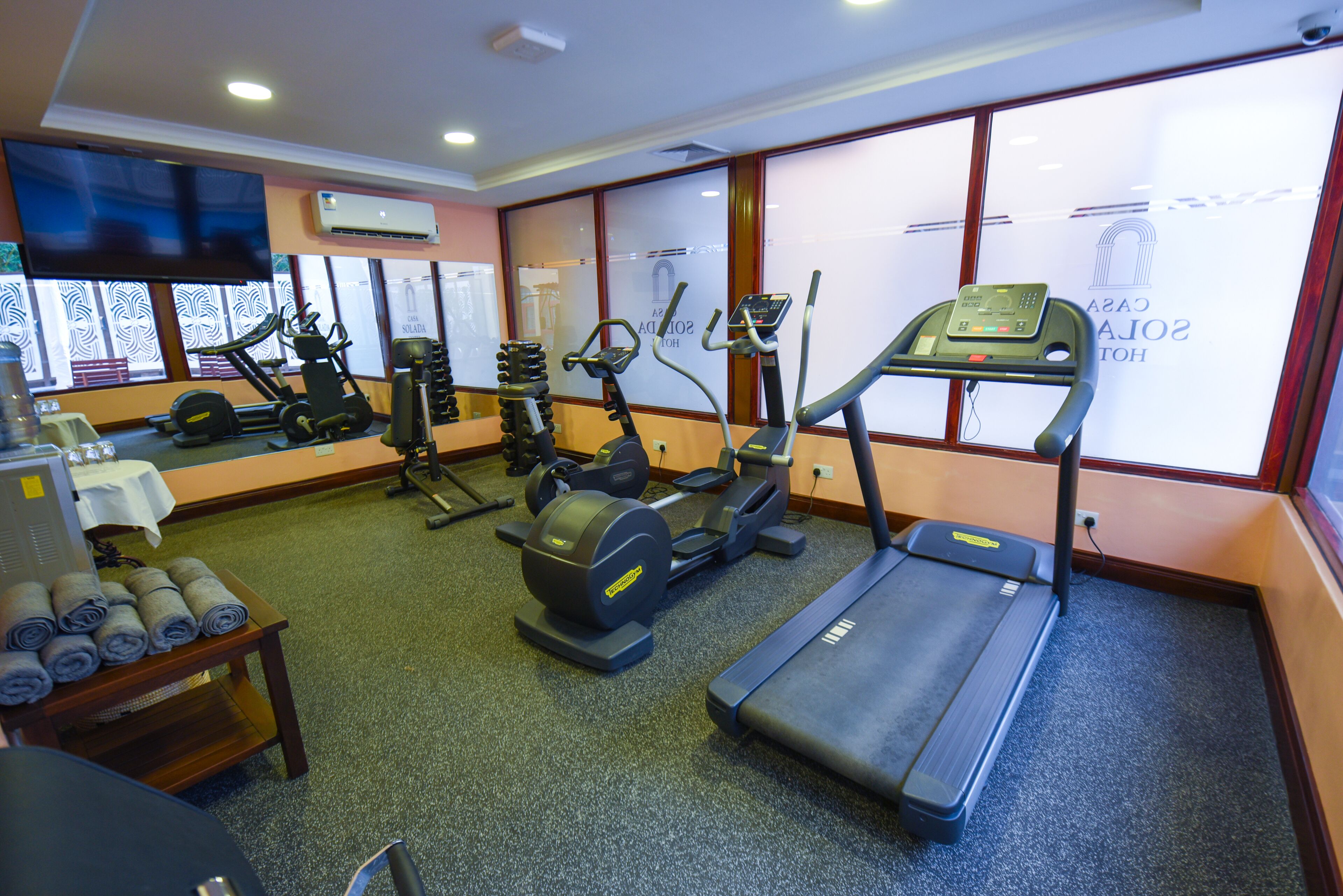 Une salle de sport équipée de tapis de course, de vélos elliptiques et d'appareils de musculation.