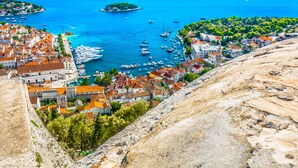 A coastal town with historic buildings, a marina, and a view of the sea. - Beach Bay Hvar Hotel (Hvar)