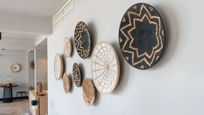 A wall with various woven and patterned wall hangings. - Beach Bay Hvar Hotel (Hvar)